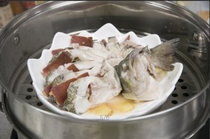將鱸魚成花狀擺好，將火腿切片放入各縫隙中，放入鍋中隔水蒸12分鐘拿出，撒上蔥花即可。