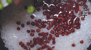 將炒好的食材和大米、紅豆一起放進(jìn)電飯鍋煮。