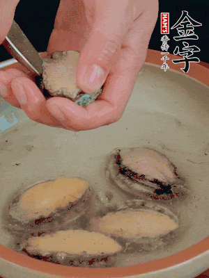 鮑魚加鹽、清水浸泡，用勺子挖出鮑魚肉。