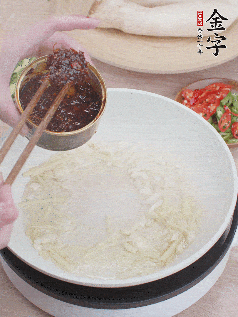 起鍋熱油，姜蒜、金字火腿干貝醬煸香。