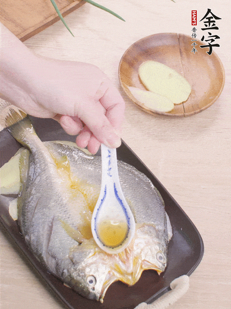 盤(pán)底鋪姜片，放黃魚(yú)，淋2勺料酒。