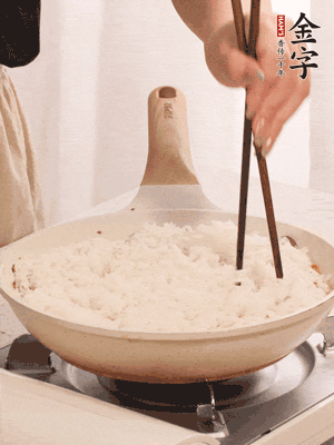 把瀝干水分的米飯均勻鋪在上面，筷子戳幾個(gè)洞，以便透氣，轉(zhuǎn)小火蓋上蓋子燜至水分收干，大概10分鐘。